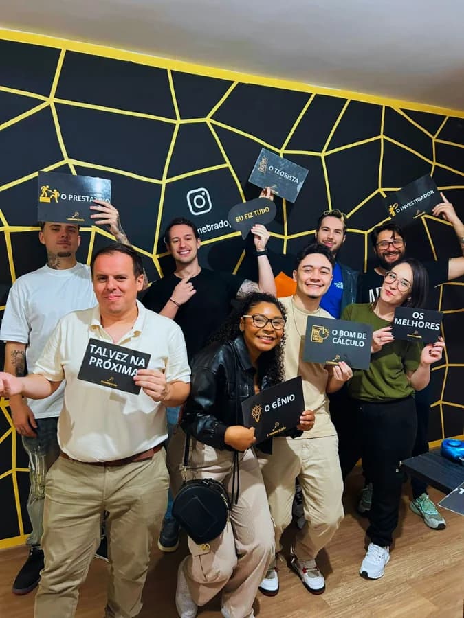 Datatchê team at an escape room get-together, holding nickname signs