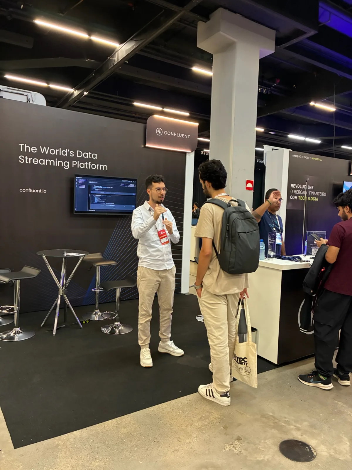 Confluent booth with a team member welcoming a visitor