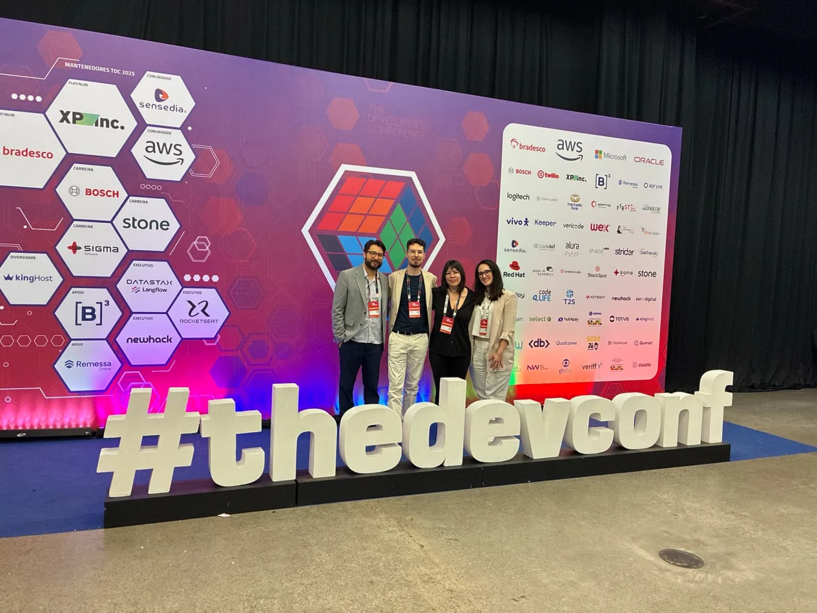 Datatchê team in front of the #thedevconf wall at The Developer's Conference